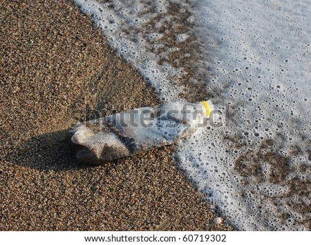 plastic bottle and dust on beach sand