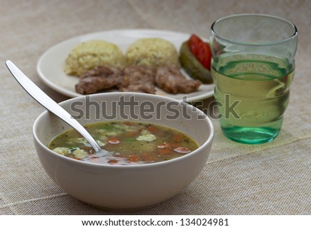 Hot vegetable soup. Pork tenderlion with rice. Glass of white wine.