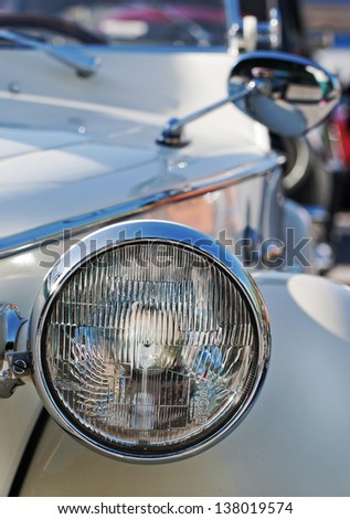 Image of front view of a vintage car. Circle headlamp.
