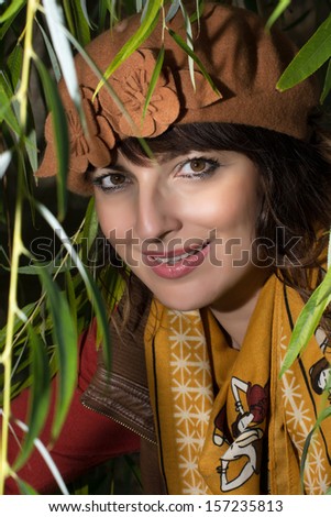 Portrait of a beautiful caucasian woman under tree branches.
