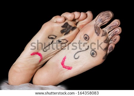 Painted expression faces on the woman\'s feet.