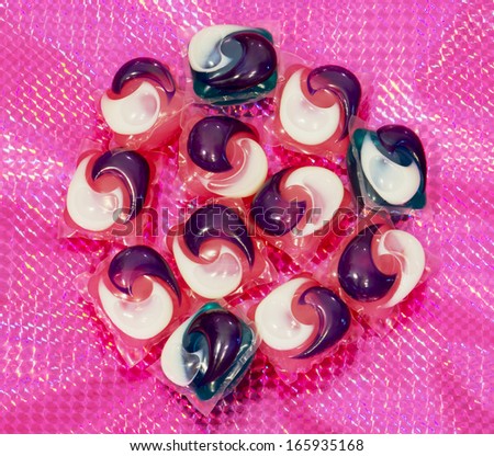 Gel capsules for washing machine on a purple background.