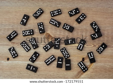 Black dominoes scattered on the table.