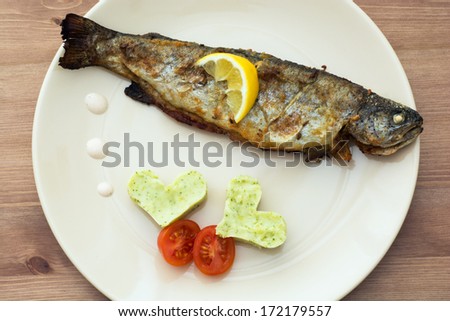 Delicious grilled trout with two hearts of mashed potatoes and cherry tomatoes.