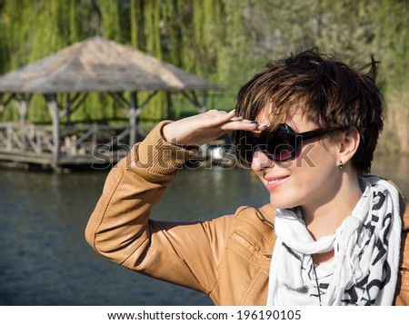 Woman looks into the distance. Posing at the lake.