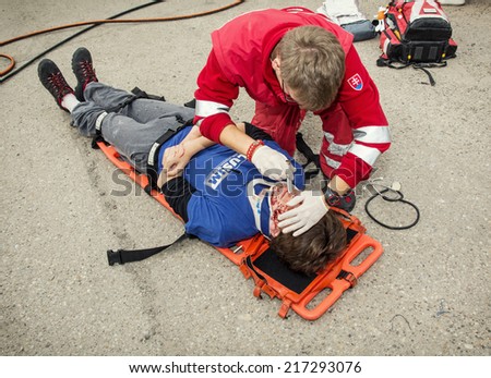 Nitra, Slovakia - September 06, 2014: Simulation of the car accident. Emergency service worker makes the control of vital functions.