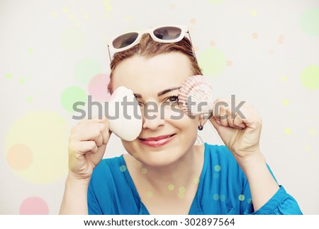 Young caucasian woman posing with sea shells. Beauty, fashion and holiday. Colorful bokeh circles defocused lights.