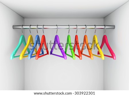 Colorful wooden cloth hangers on clothes rail in white wardrobe
