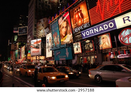 Times Square at night with traffic and yellow cabs