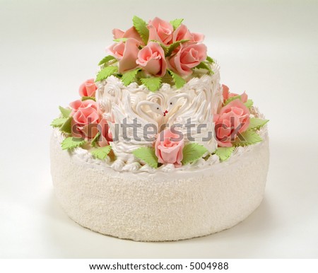 A cake with white frosting, cake is decorated with purple roses.