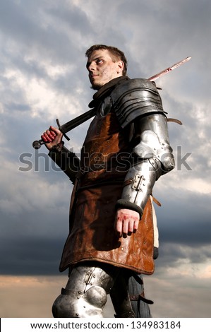 Knight holding sword on a sky background