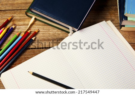 Blank paper and colorful pencils, on the wooden table. View from above. School concept.