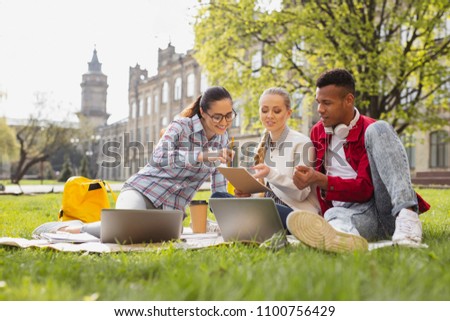 First year. First year students feeling curious while looking at their university schedule sitting outside