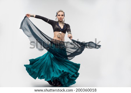 full length portrait of beautiful oriental women,dancing, in a fit of passion, with her amazing scarf. Isolated on white background