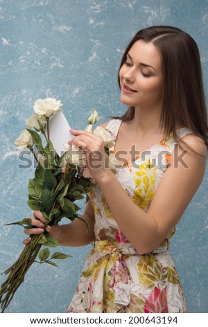 Half length portrait of pretty young girl, receiving beautiful bunch of roses and love letter from her boyfriend.