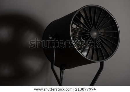Turned on spotlight standing with the shade. Isolated on grey background