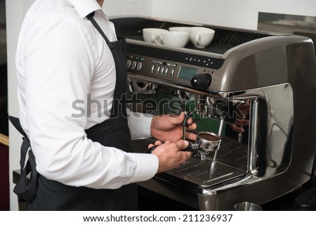 Half-length portrait of professional barista preparing coffee for visitors