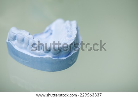 Portrait of the false tooth lying on the white surface