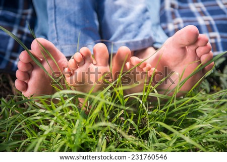 Someones bare feet lying on the grass