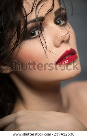 Selective focus on the beautiful sexy dark-haired woman with great evening make- up looking at us seductively