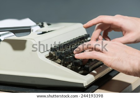 Working at the typewriter. Close-up of man typing something on typewriter