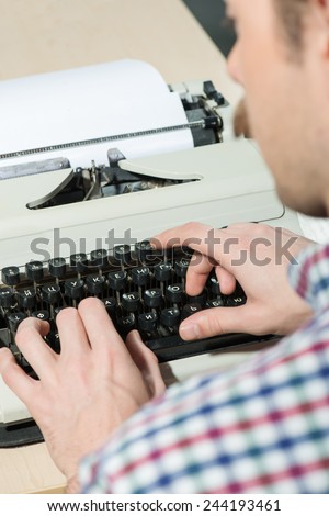 Working at the typewriter. Close-up of man typing something on typewriter