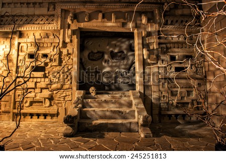 Mystery of Aztec temple. Image of ancient temple stylization depicting scull facade and steps surrounded by stone walls and vine