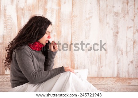 Coughing beauty. Side view image of young sick woman with scarf on her neck sitting in bed and coughing with her country house on the background