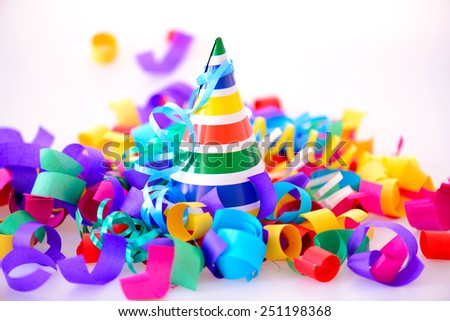 It is a special day. Image of a bright party hat surrounded by multi colored confetti and popper isolated on white background with copy space