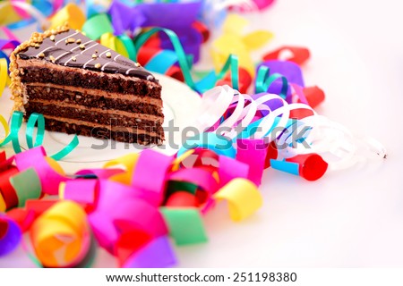Birthday cake. Closeup top view of a piece of chocolate cake decorated with confetti isolated in white background
