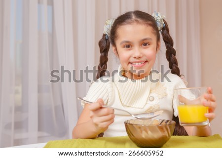Home meal tastes perfect. Small school girl having a meal smiling to the camera