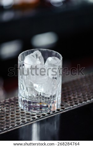 Ice age. Close-up of a glass with ice standing on a bar counter