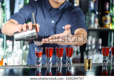 Night club. Barman using a shake mixer cocktails and drinks in nightclub, bar or pub