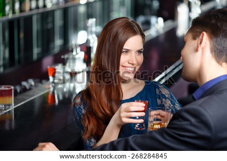 Nice to meet you. Young charming girl woman toasting with an attractive stranger sitting in the bar