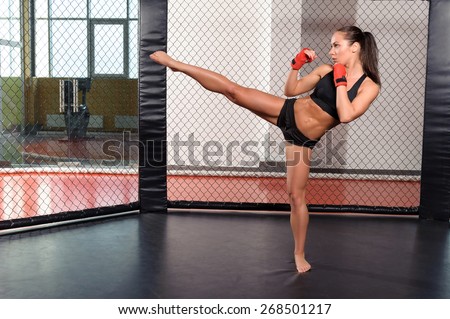 High kick. Strong sportswoman shows her high kick in a boxing ring