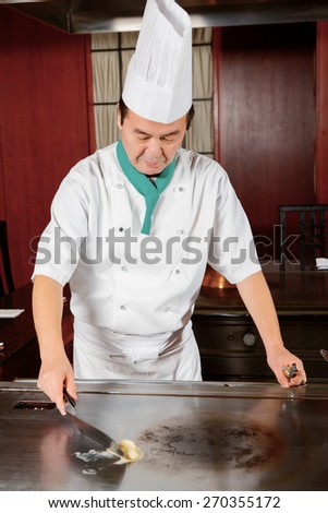 Professional cook. Chef-cook melting butter on a stove getting ready for cooking a dish