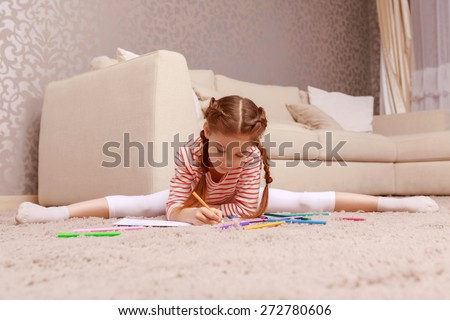 Studing through gymnastic. Cute little girl drawing with splitting legs apart.