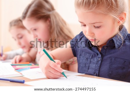 Careful work. Close up of  pretty little girl carefully drawing with help of marker.
