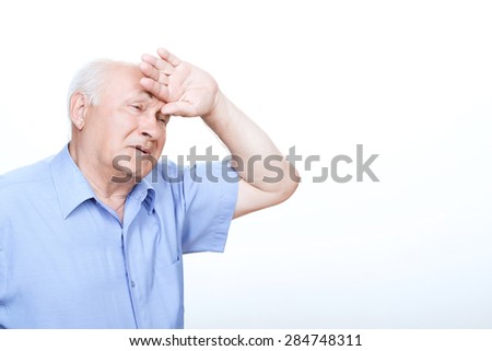 Feeling worn out. Exhausted grandfather holding left hand on the forehead while standing half-turned isolated on white background.