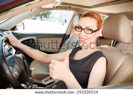 Self-confidence. Pleasant youthful businesswoman sitting inside her luxurious expensive car.