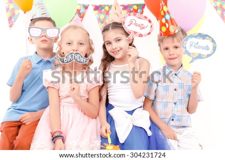 Creative picture. Portrait of little cute children holding small tags with birthday related signs during party