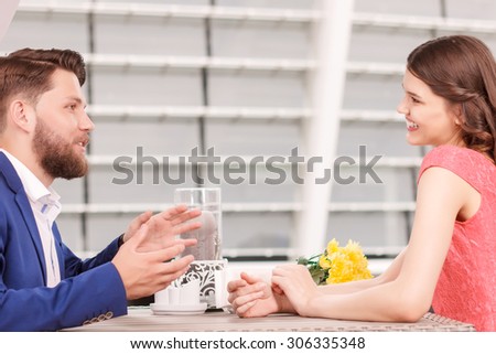 Expressive conversation. Portrait of handsome young man and smiling pretty woman sitting in cafe and having conversation.