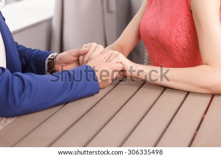 Strong love. Close up portrait of young couple holding hands of each other.