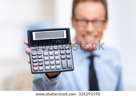 Wise device. Selective focus of calculator in hands of professional lawyer holding it and being involved in work