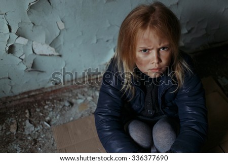 Grief in glance. Top view of depressed sad little girl sitting on the floor and looking up while feeling unhappy