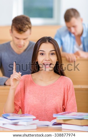 Finding solution. Young attractive excellent student looks enlightened with sudden solution while sitting at the desk and doing intellectual tasks.