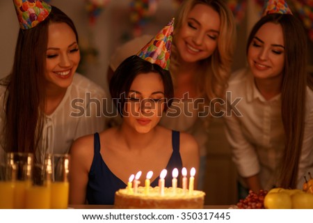 Make a wish. Young attractive girl is about to make a wish and blow all candles.