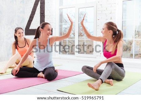 Three young girls giving high five in fitness studio