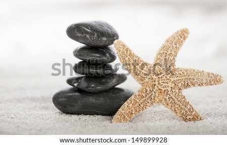 Stacked stones and starfish on sand in a Japanese ornamental or zen garden.