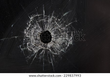 bullet holes in glass isolated on black